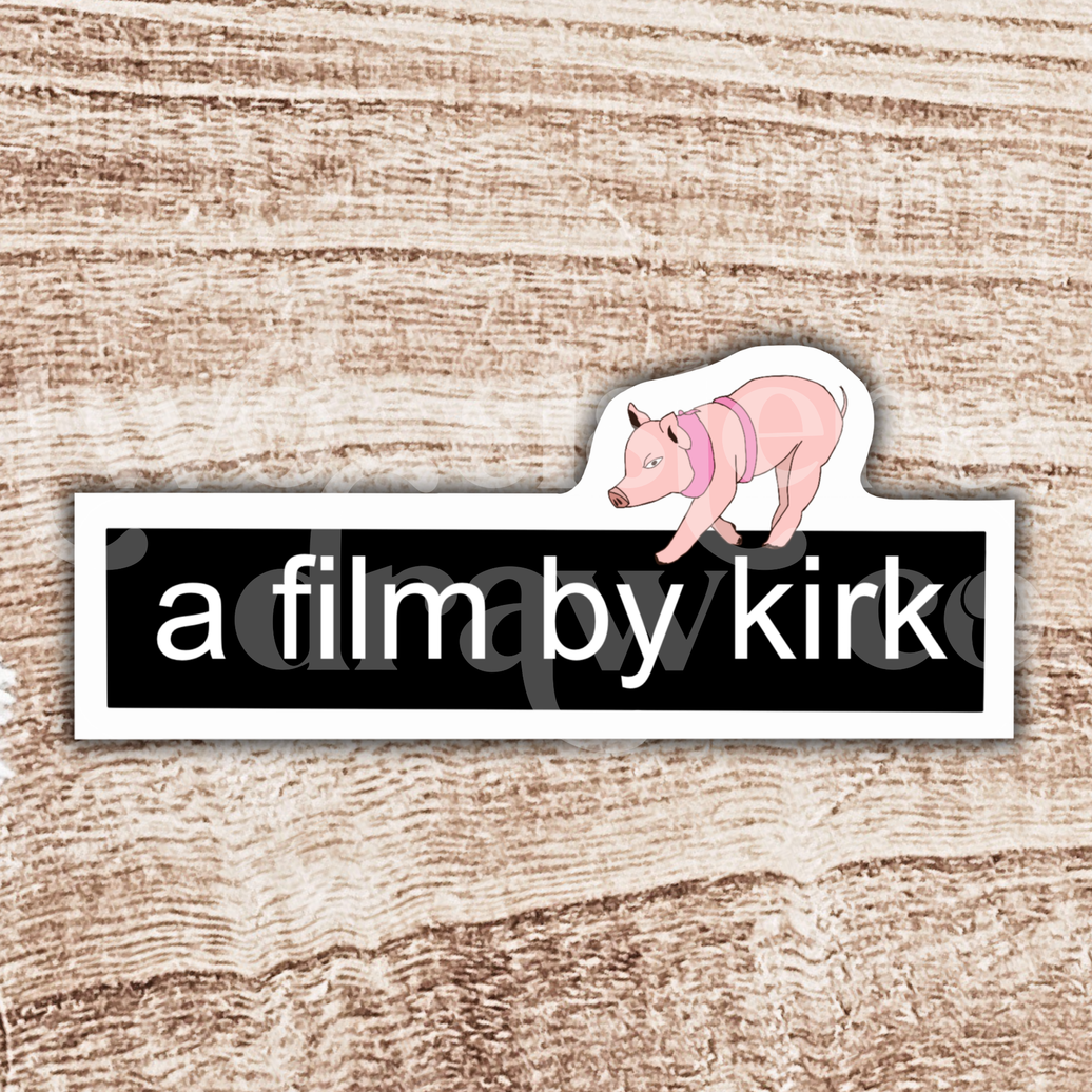 Gilmore Girls sticker with the text 'a film by kirk' and a mini pig on top on a wooden background.