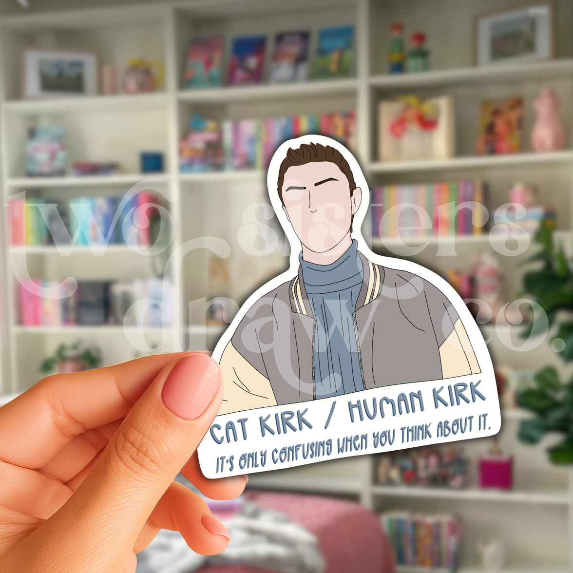 Person holding a hand-drawn Kirk Gleason sticker with the text, 'Cat Kirk/Human Kirk, it's only confusing when you think about it' underneath in front of a bookshelf.