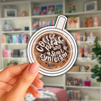 Person holding a hand-drawn illustration of a coffee cup sticker with text 'Coffee please and a shot of cynicism' in front of a book case.