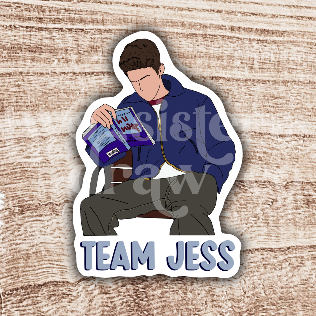 Sticker of Jess Mariano sitting on a bench reading with 'Team Jess' text on a wooden background.