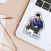 Hand-drawn Team Jess sticker featuring Jess Mariano reading on a bench on a white background, placed on a laptop.