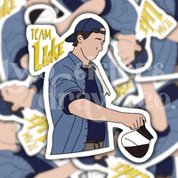 Hand-drawn sticker of Luke Danes pouring coffee with the text ‘Team Luke’ with a patterned background. 