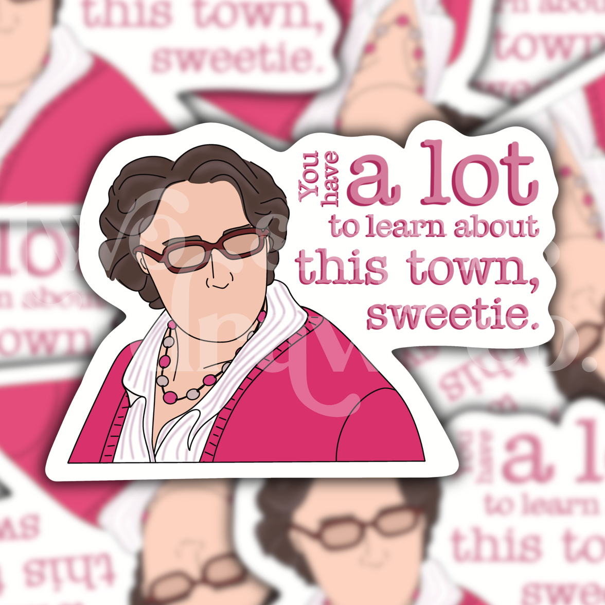 Hand-drawn sticker of Phyllis Vance from The Office in a pink outfit and glasses with the text ‘you have a lot to learn about this town, sweetie’ on a patterned background.
