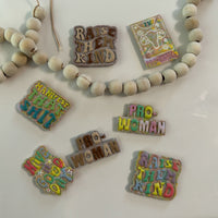 Close-up of handmade, polymer clay magnets featuring 3D bubble lettering in sherbet and neutral color palettes on a white background with wooden beads